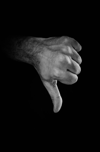 Foto B/N di una mano maschile con il pollice verso.
