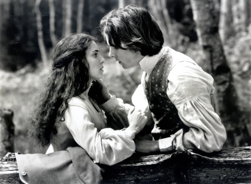 Foto in bianco e nero di un ragazzo e una ragazza in abiti d'epoca, in procinto di baciarsi.